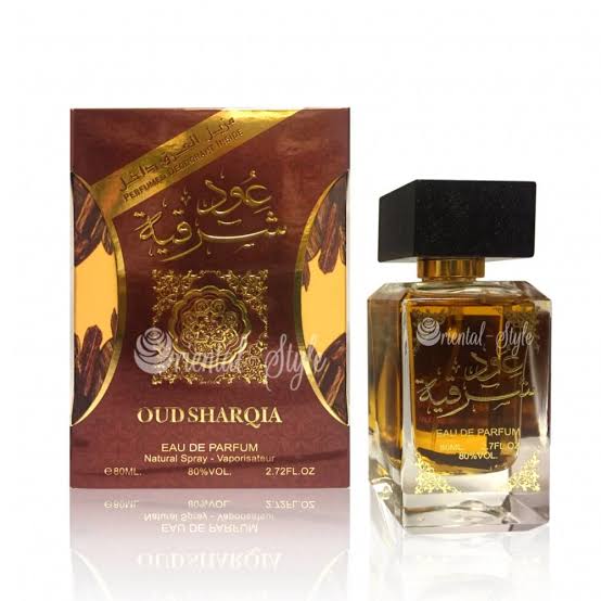 Oud Sharqiia Eau de Parfum shown with its retail box and the clear glass bottle. The packaging is dark brown and gold with Arabic calligraphy, and the bottle contains amber-colored liquid with a black cap.