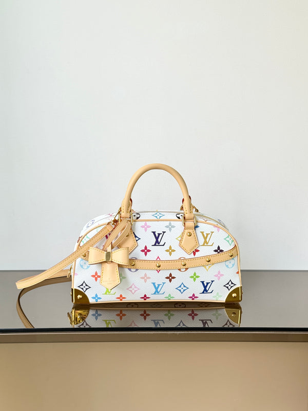 A Louis Vuitton monogram handbag in white coated canvas with multicolor printed monogram motifs, tan leather handles and trim, and gold-tone hardware, displayed on a reflective surface against a plain light background.