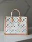 A Louis Vuitton handbag with a white canvas body covered in a colorful multicolor monogram pattern, featuring light pink leather trim, double top handles, and gold-tone hardware, set against a gray marble background.